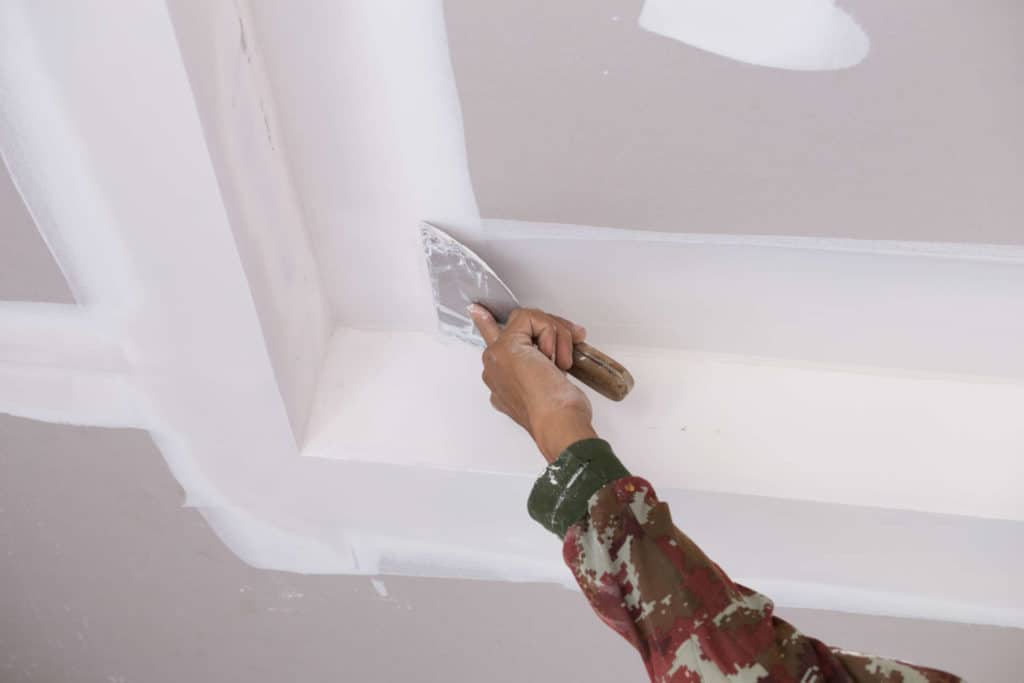 hand worker using gypsum plaster ceiling joints | แอ๊ดวานซ์ กรุ๊ป เอเซีย บริษัท กำจัดปลวก กำจัดแมลง ทำความสะอาด